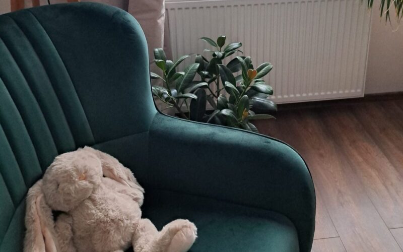 Zielony fotel z pluszowym misiem w kąciku dla dzieci