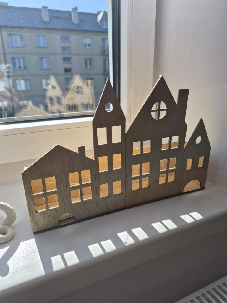 Świecąca dekoracja w kształcie domków na parapecie
