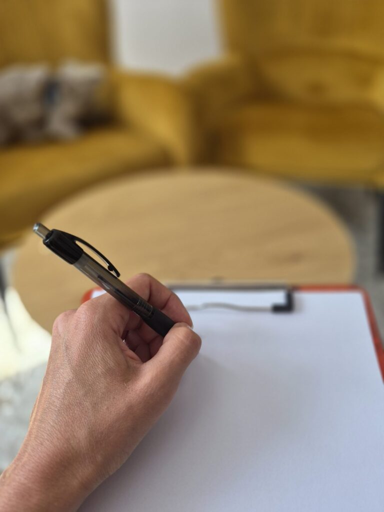 Dłoń zapisująca notatki na kartce podczas konsultacji